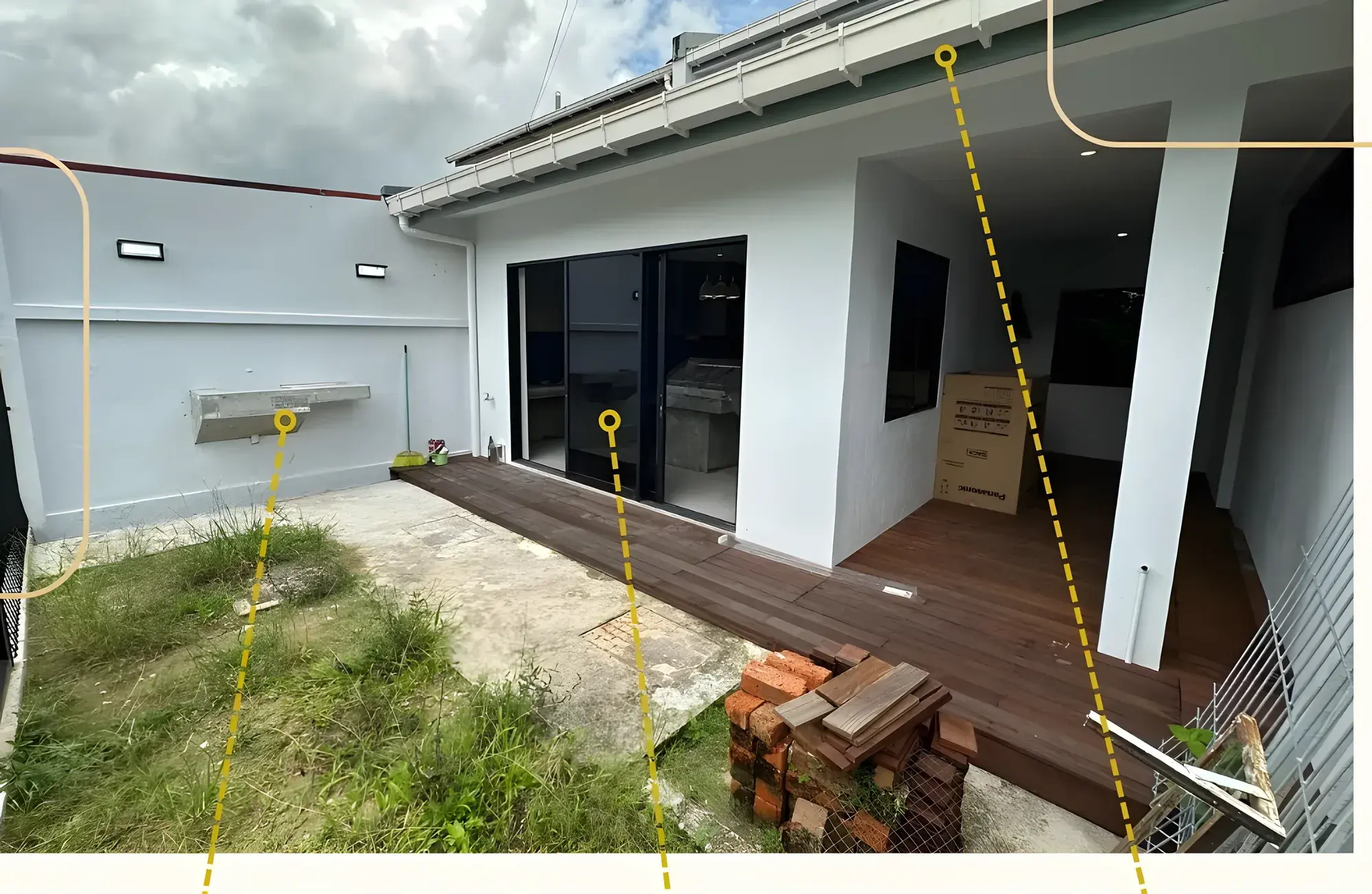 Rear of the house with new roofing and gutter, three-panel sliding aluminium doors and a timber deck.