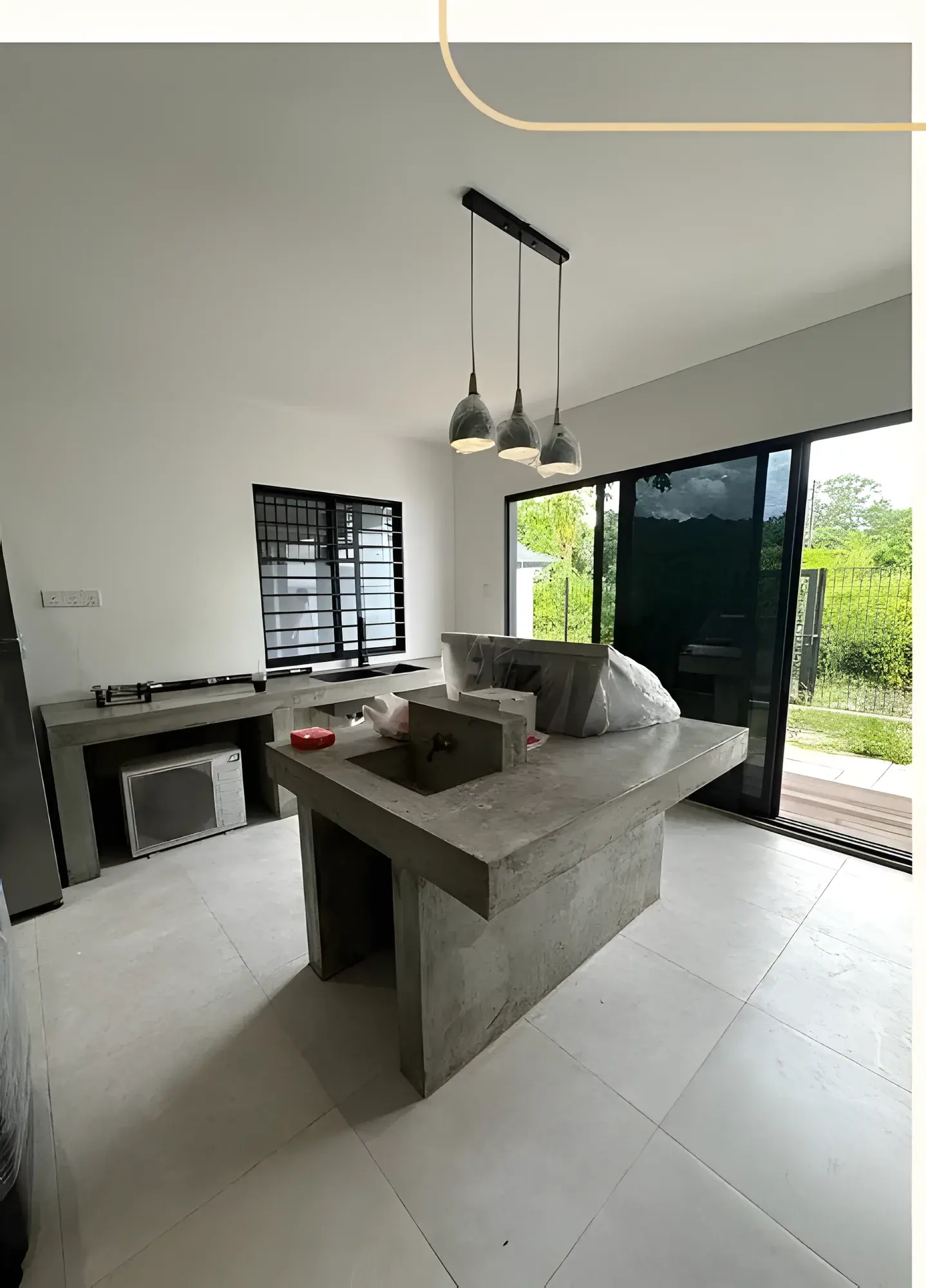 Concrete island with integrated sink, looking towards the sliding doors.