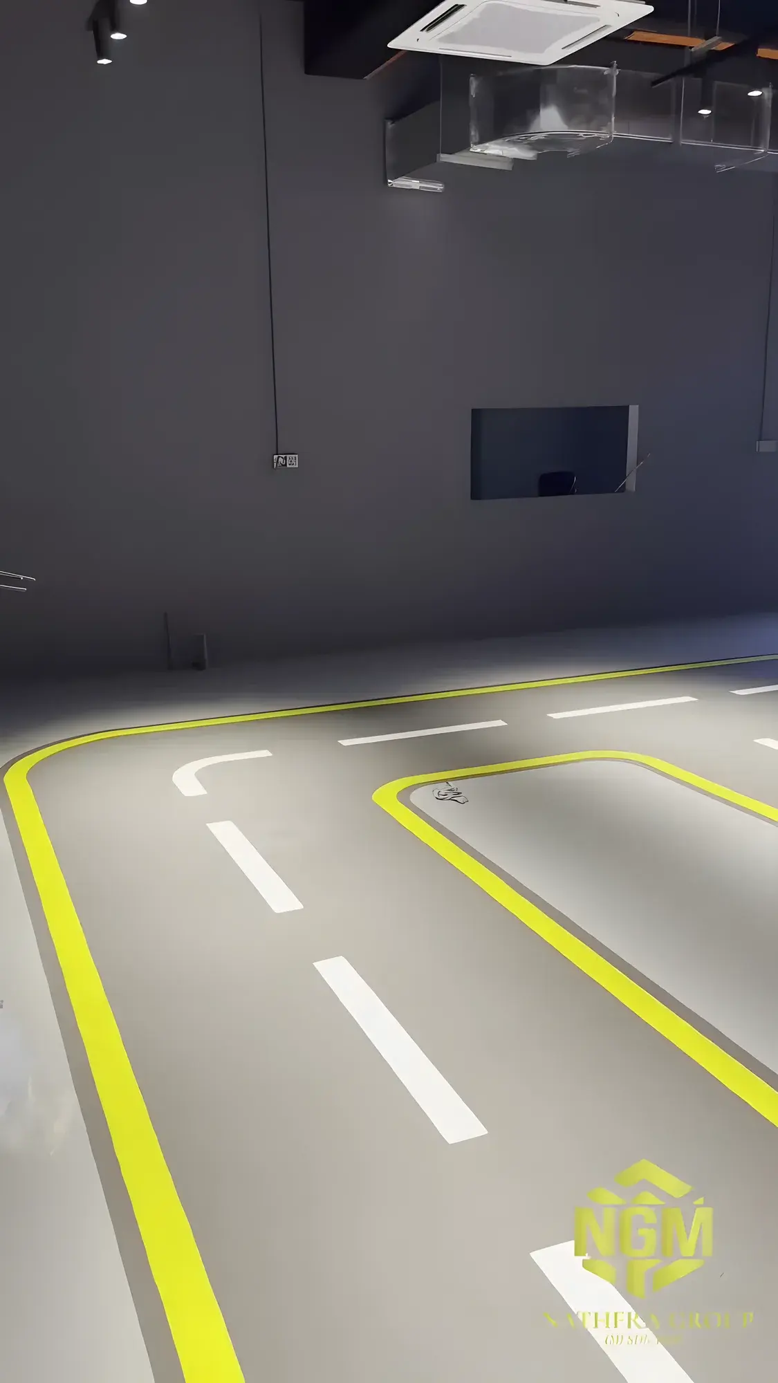Grey epoxy floor with a road layout painted in yellow and white, before the furniture went in.